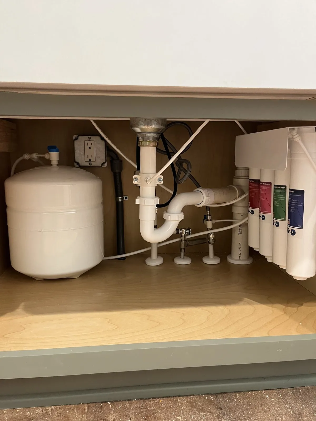 Four-stage reverse osmosis unit and storage tank under a kitchen sink